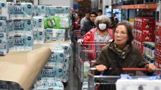 A line of shoppers wait to collect toilet paper at a Costco store in Novato, California on March 14, 2020. - Hoards of shoppers rushed to stock up on toilet paper, paper towels and cleaning supplies as communities begin hunkering down as a result of the Coronavirus. (Photo by Josh Edelson / AFP) (Photo by JOSH EDELSON/AFP via Getty Images)